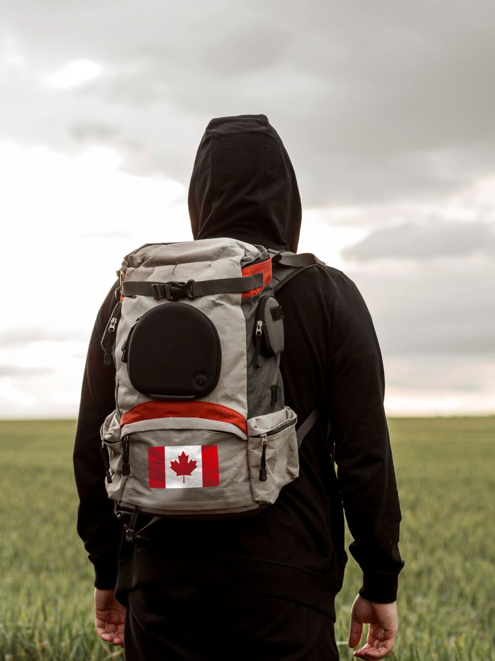 man-carrying-backpack-with-canadian-flag