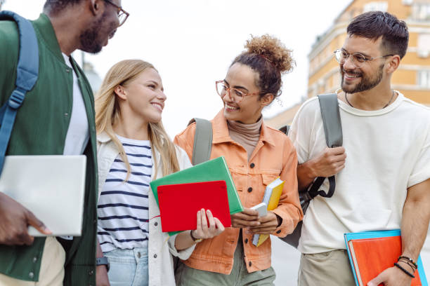 Group of University students standing on the street and discussing about class